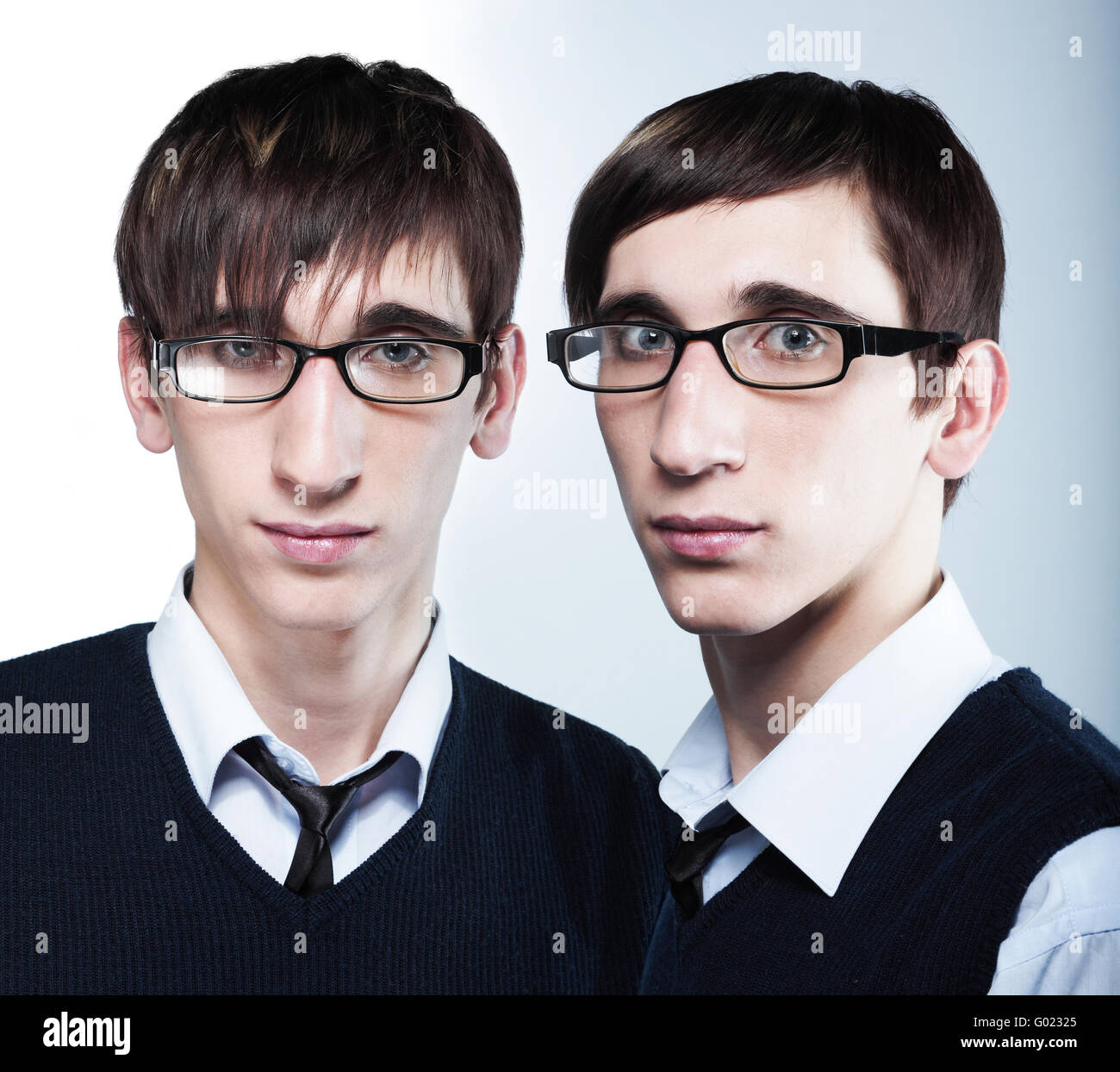 cute young twins with fashion haircuts wearing glasses Stock Photo