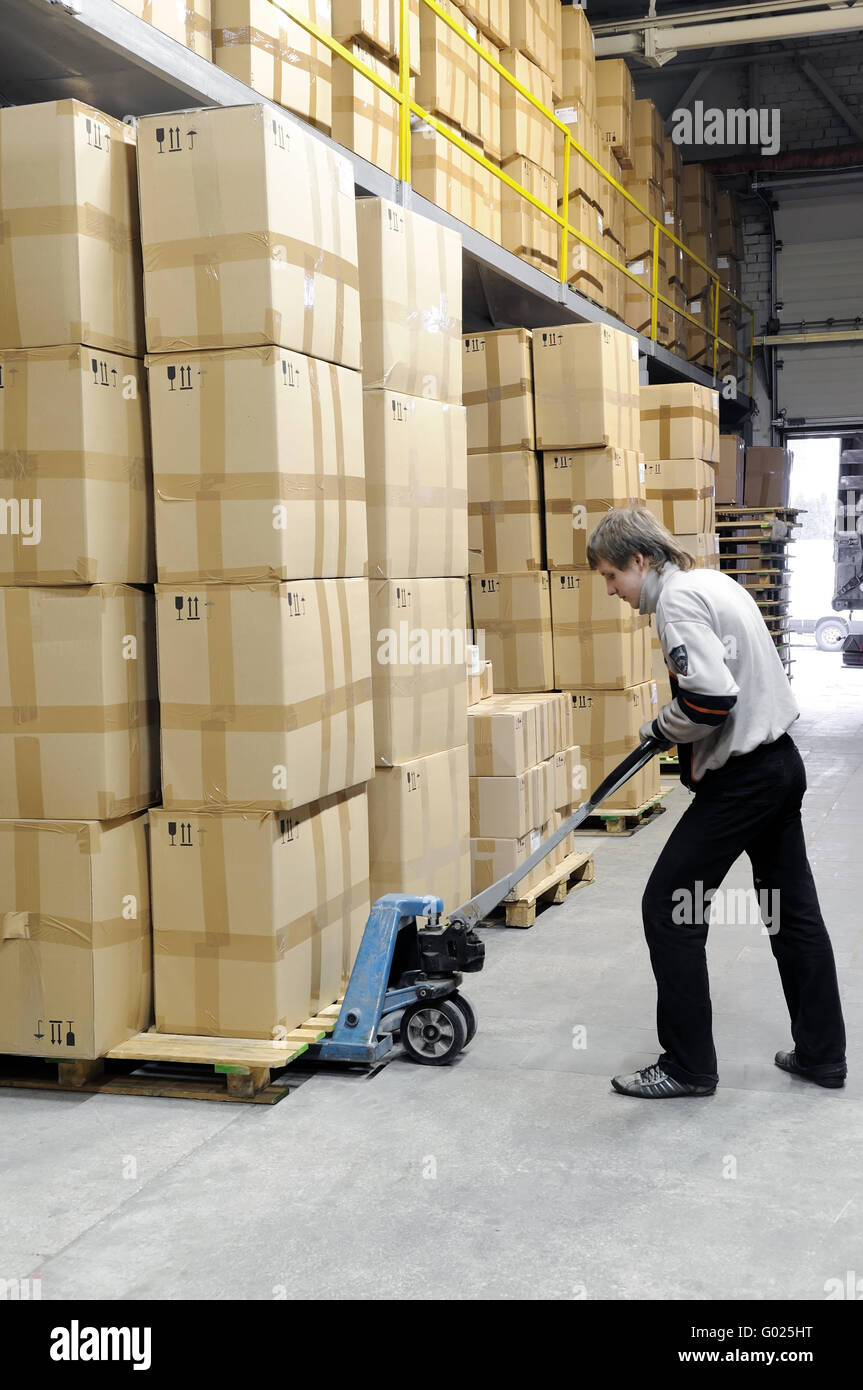manual fork pallet truck operator in warehouse Stock Photo
