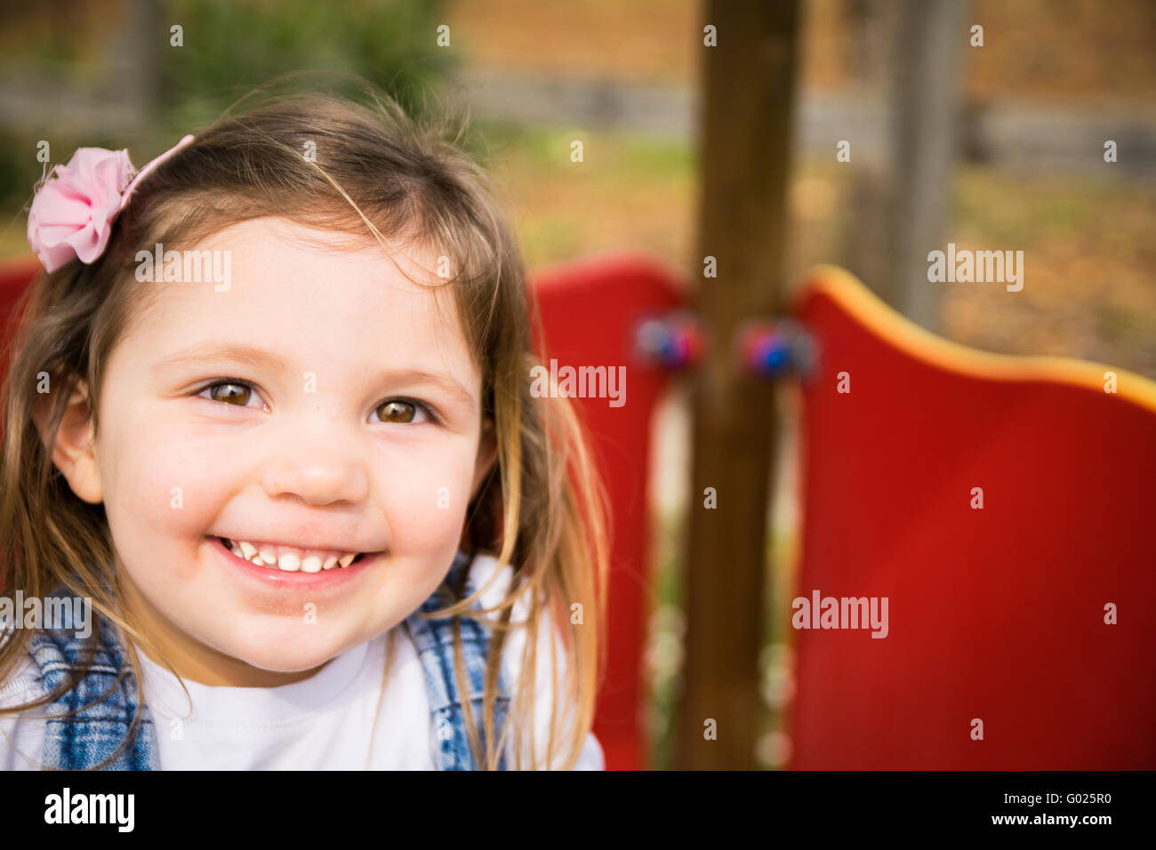 Little girl smiling on the structure of a playground Stock Photo - Alamy