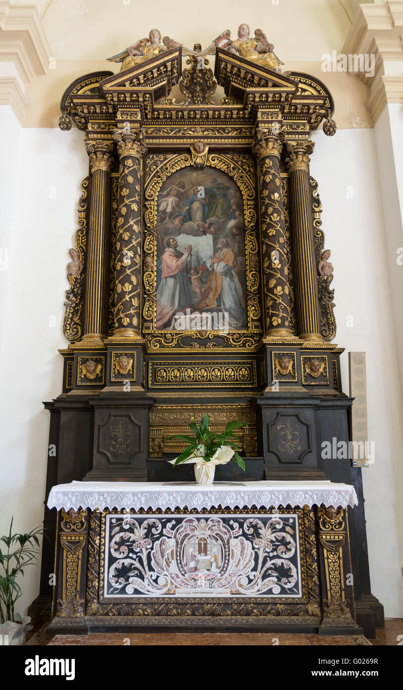 Marostica, Italy - April 12, 2016: Wooden altar dedicated to the coronation of the Virgin, richly carved with gilded reliefs. Stock Photo