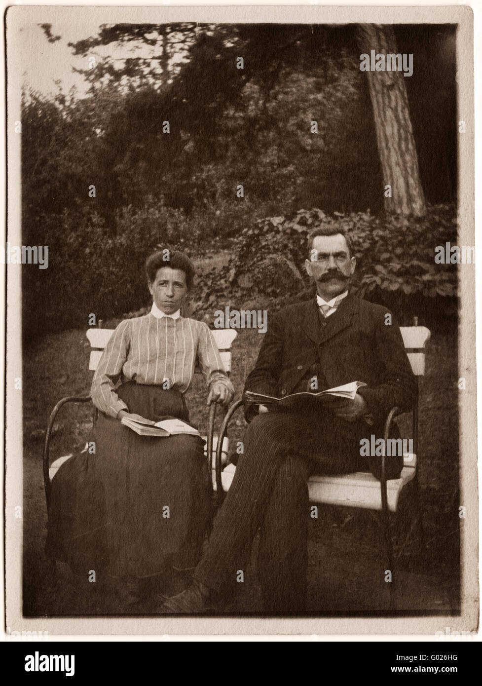 couple with newspaper on a park bench, historic photograph, around 1920 Stock Photo