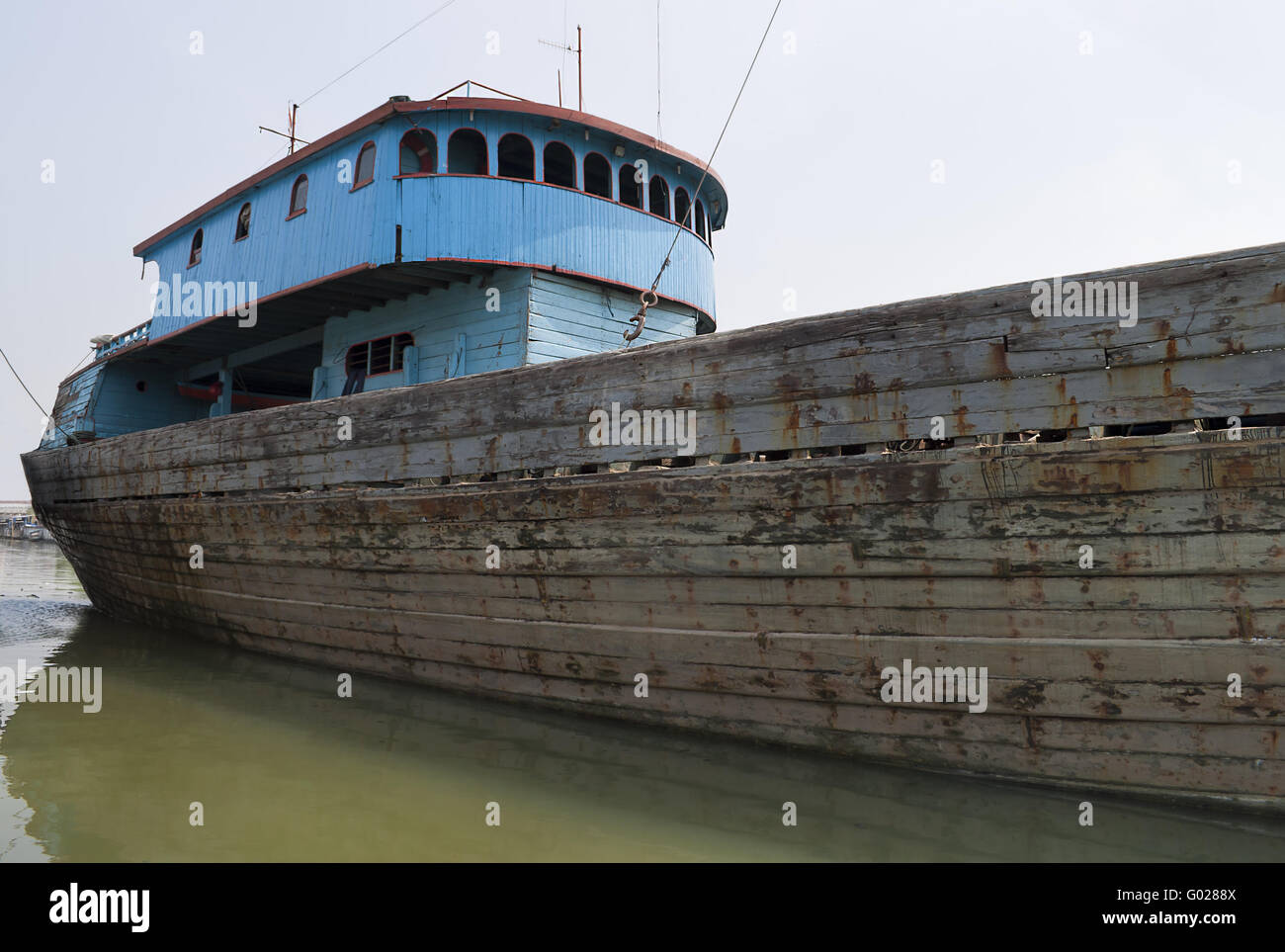 Blue rusty vessel in a canal in Jakarta harbor Stock Photo