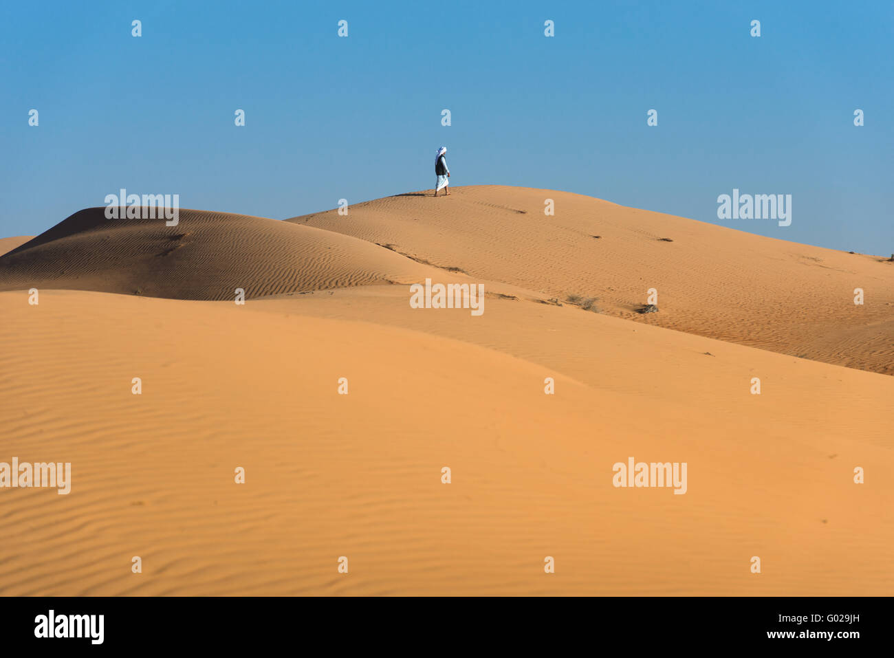 man walking in Wahiba Sands, Oman Stock Photo