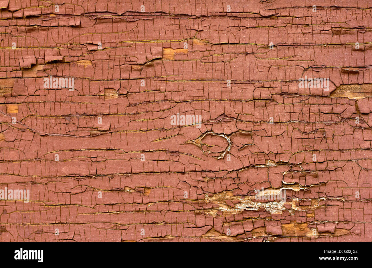 Old red oil paint peeling away from wood surface. Stock Photo