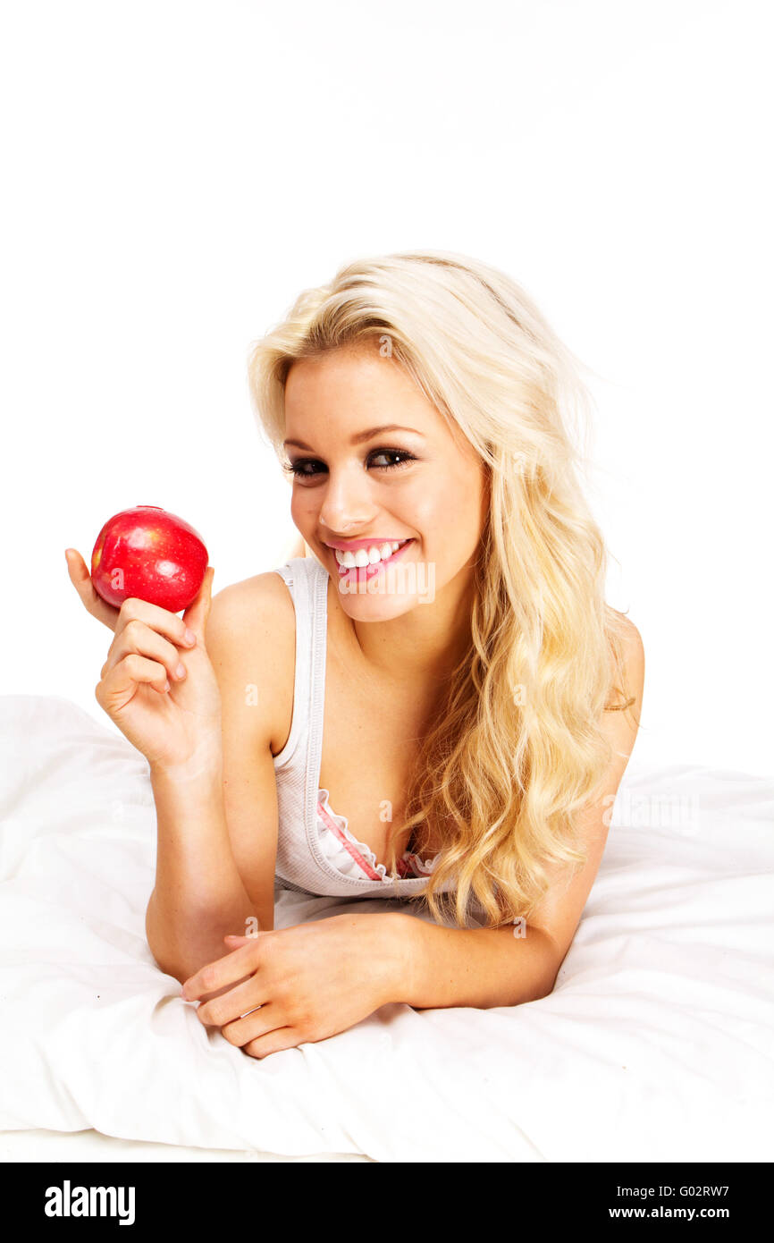 Beautiful young woman  with red apple on bed Stock Photo