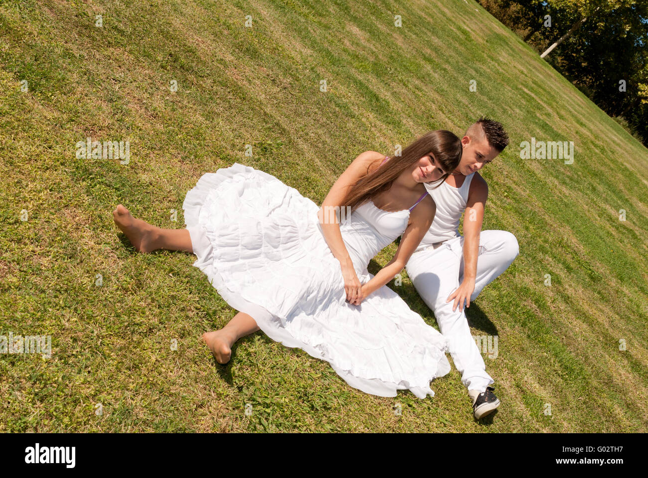 young couple happy sitting on grass white clothes Stock Photo - Alamy