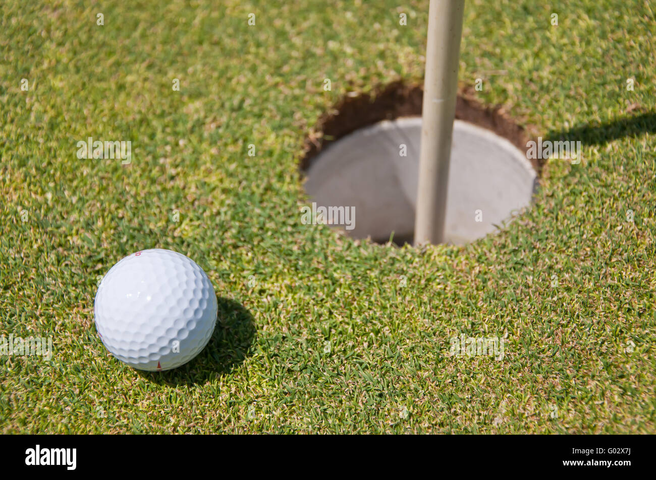 golf hole with ball and flag Stock Photo