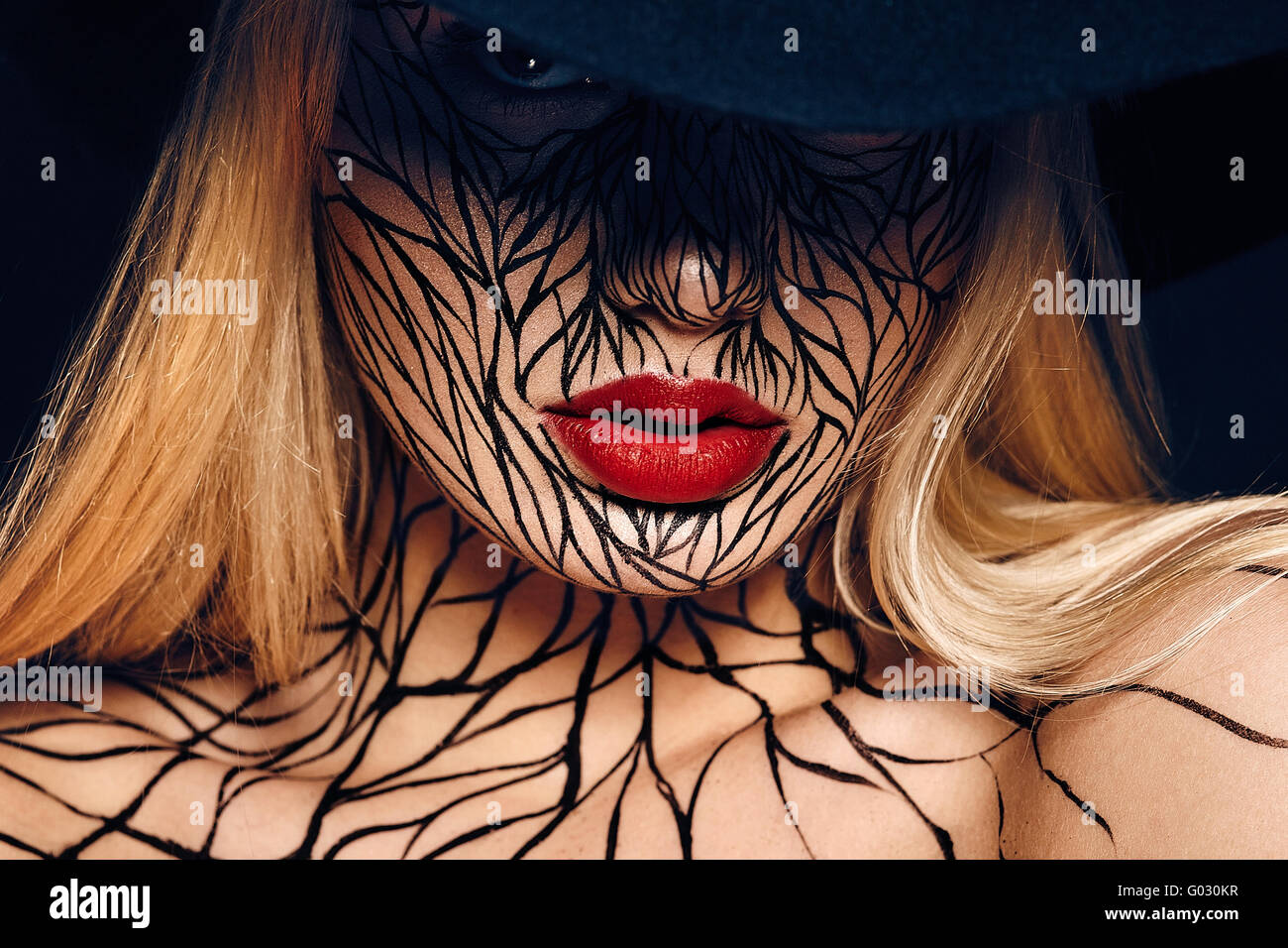 fashion portrait of girl with faceart and red lips. Picture taken in the studio on a black background. Stock Photo