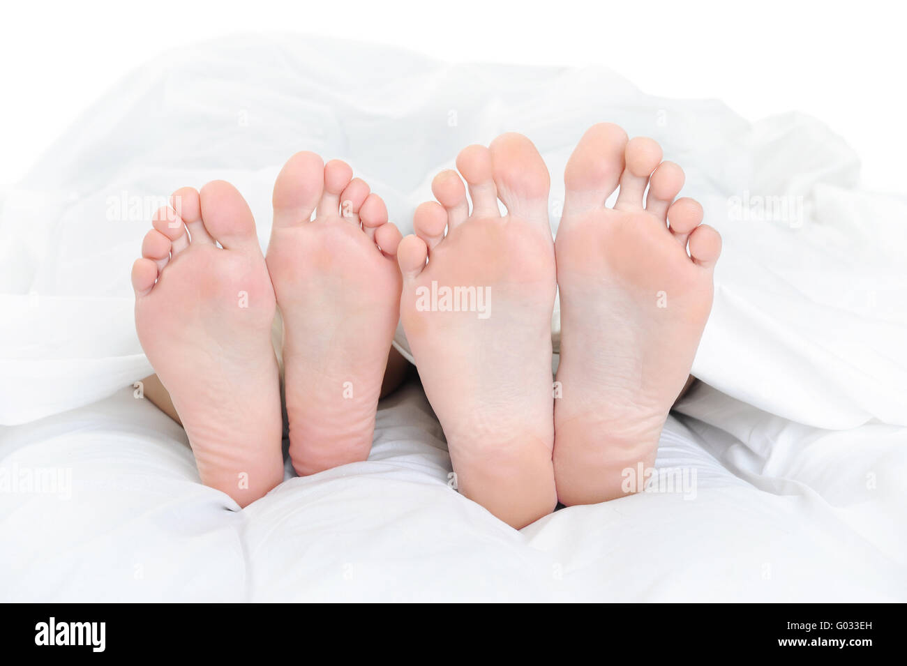 Close-up of the feet of a couple on the bed Stock Photo