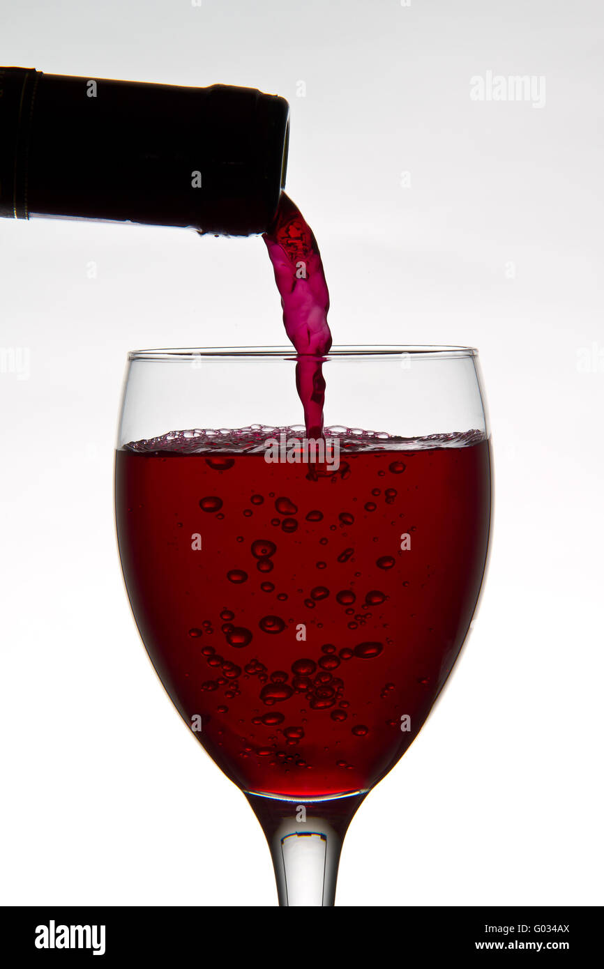 red wine pouring down from a wine bottle Stock Photo