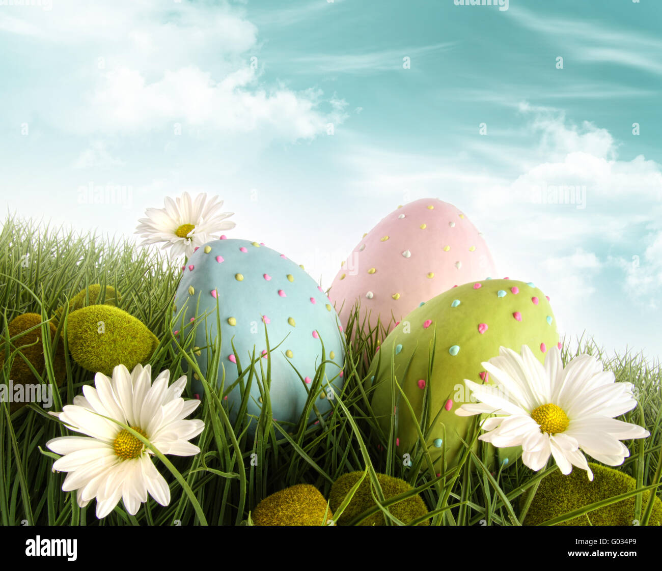 Decorated easter eggs in the grass with daisies Stock Photo