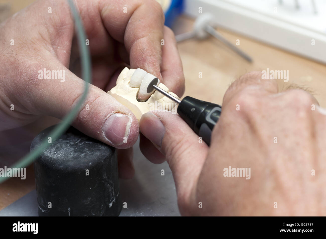 Dental technician in the grinding of artificial te Stock Photo