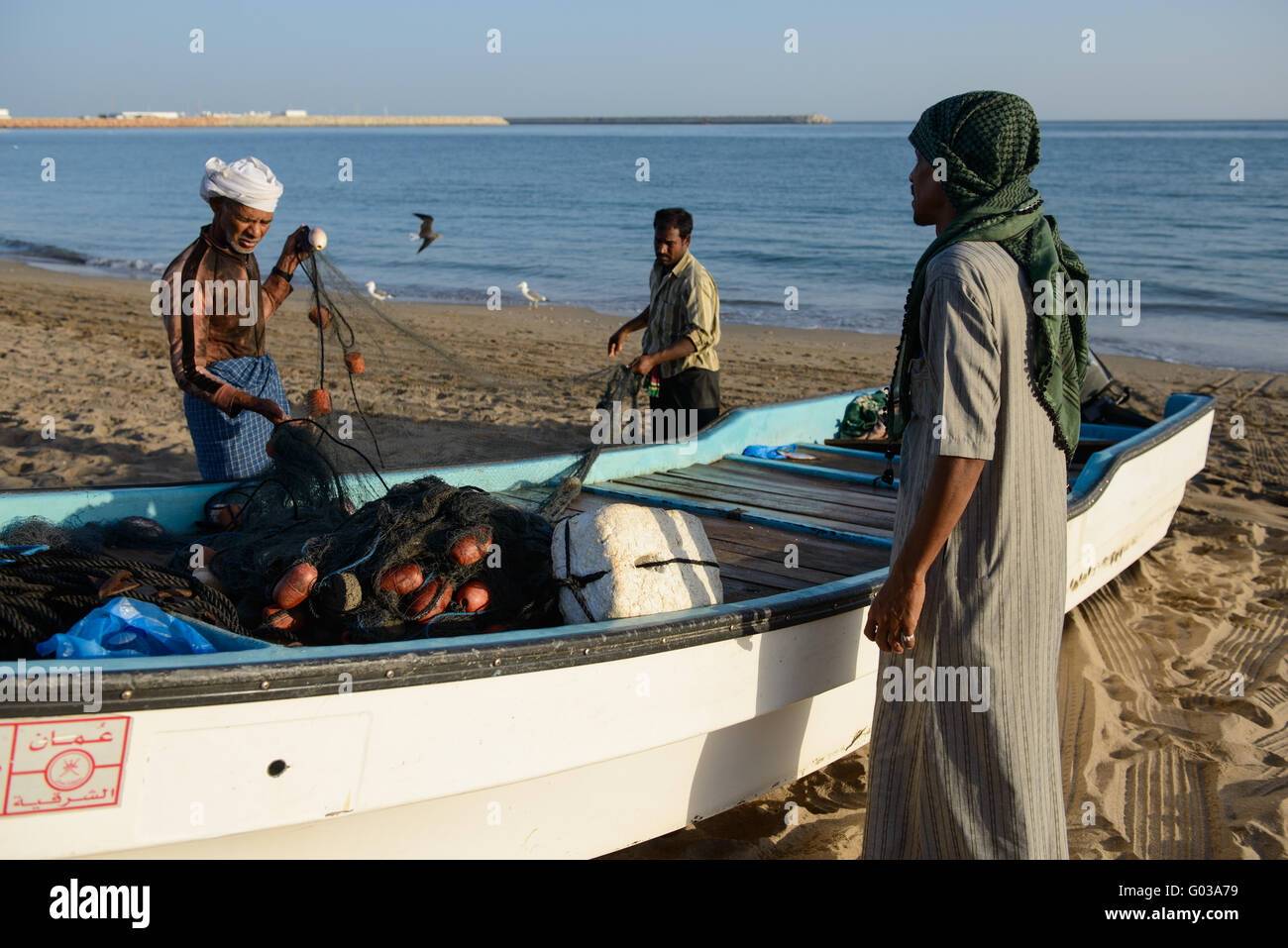 Fishermen working on their nets, Sur, Oman. Stock Photo