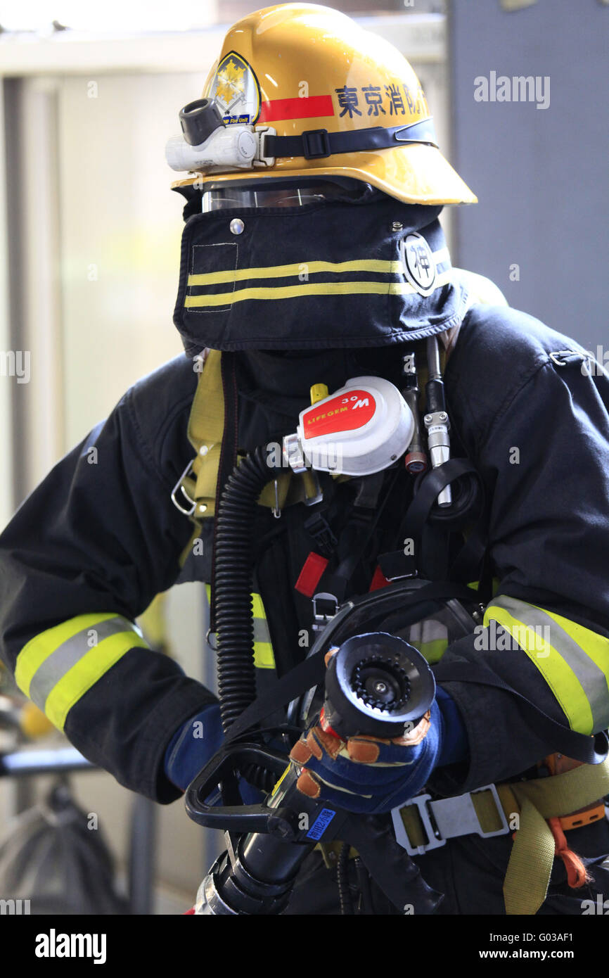 Firefighter with protective gear and hose Stock Photo