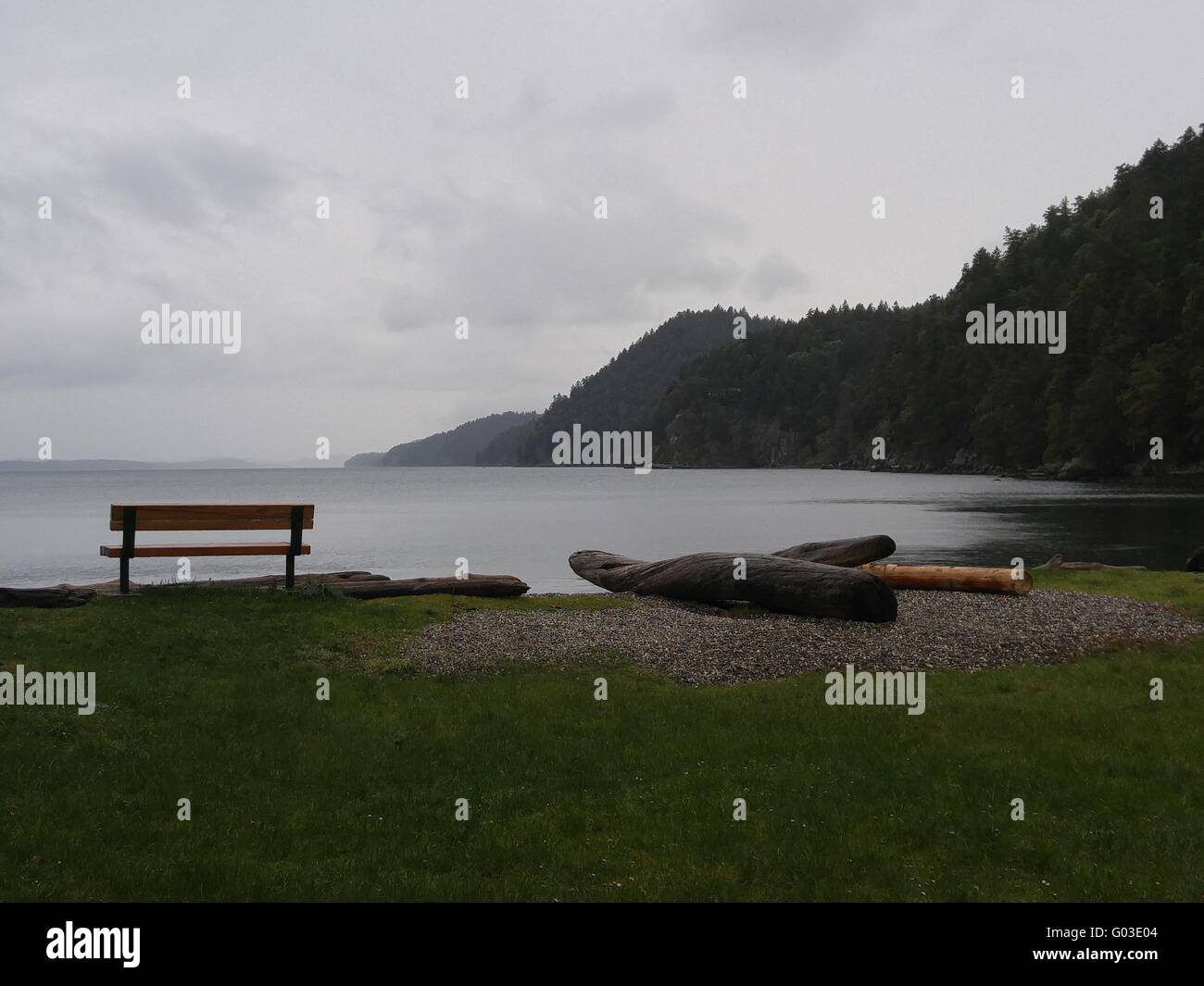 Misty winter day on the Pacific Coast with shoreline and inviting bench. Stock Photo