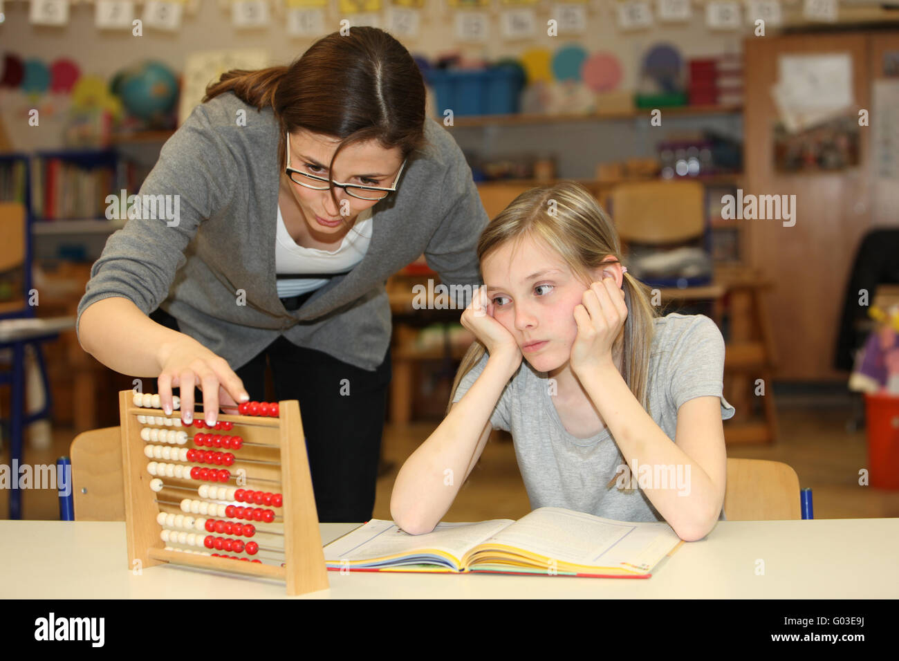 a teacher and pupil count together in school Stock Photo