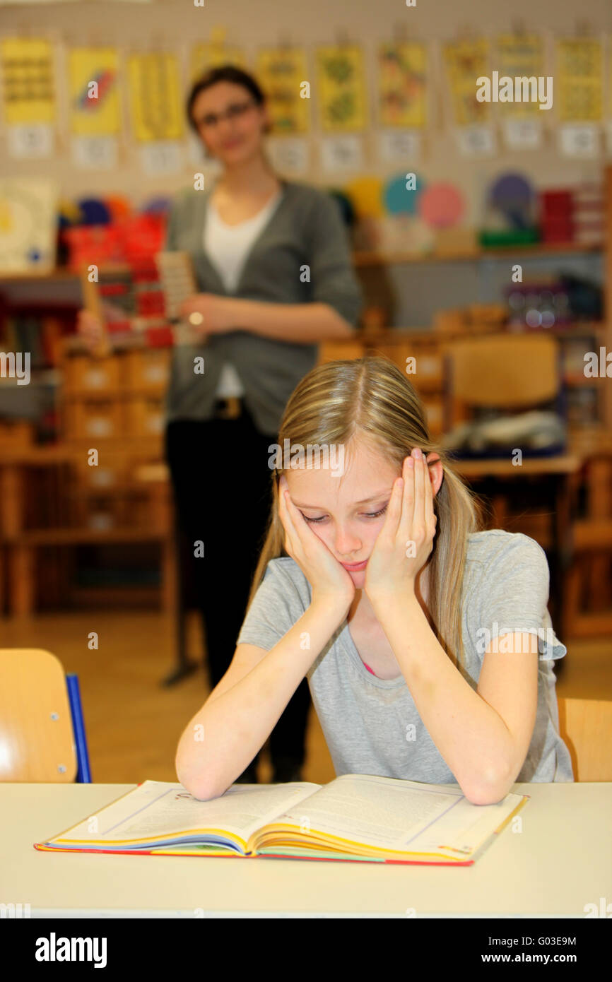 Stressed-out student in the school with a book in Stock Photo