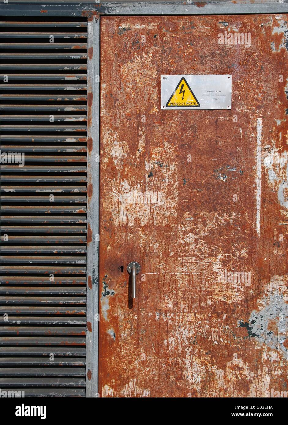 danger high voltage sign on a rusty metal door Stock Photo