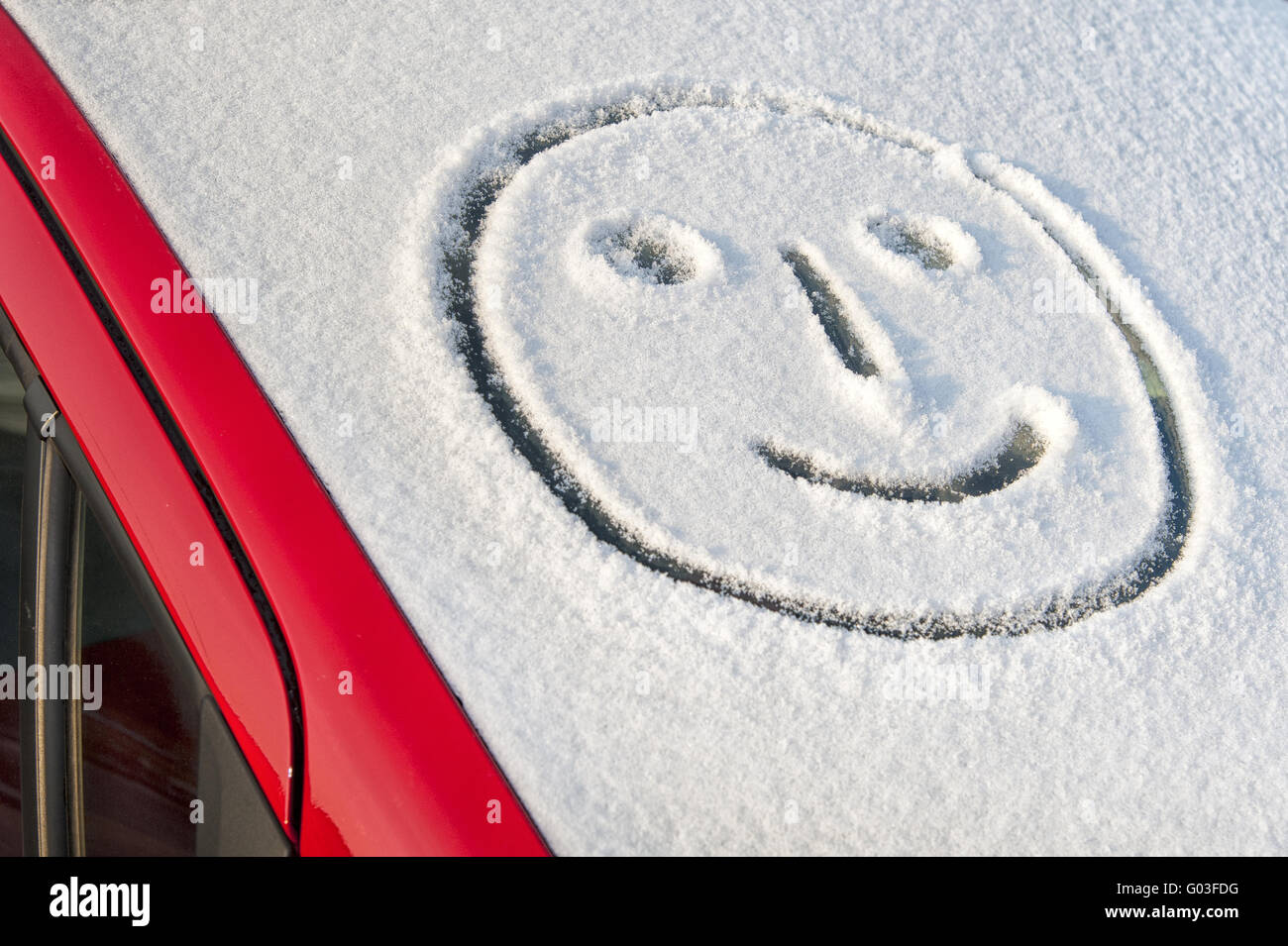 smiling face in the snowy front window of a car Stock Photo