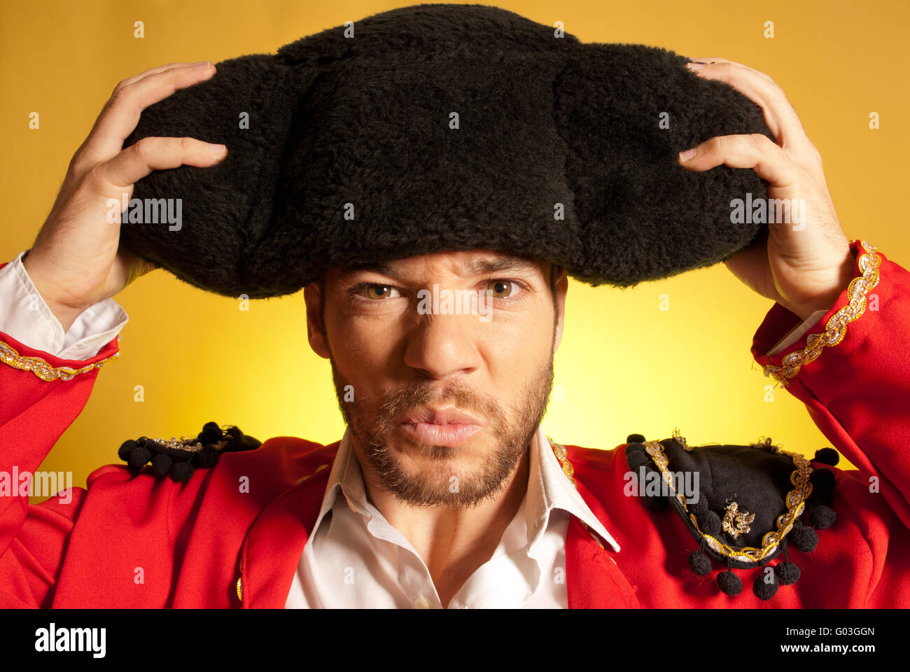 Bullfighter putting on big montera hat humor spanish colors Stock Photo