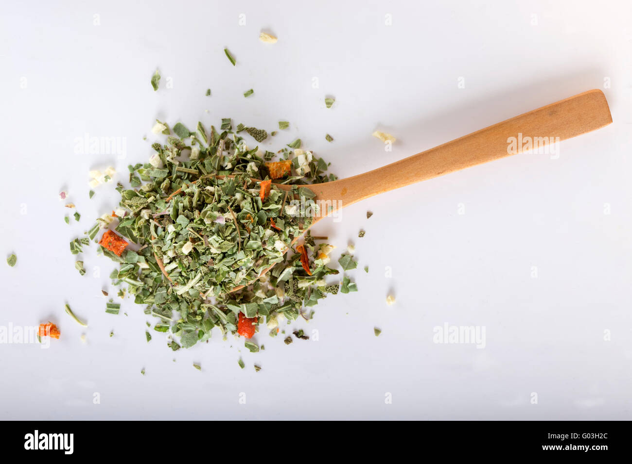 Wooden spoon with Italian seasoning - dried oregano with thyme, basil and vegetables Stock Photo