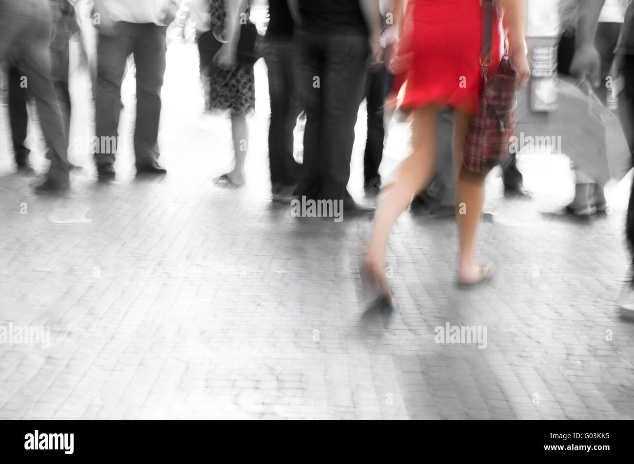 Busy big city street. Woman in red among black and white Stock Photo