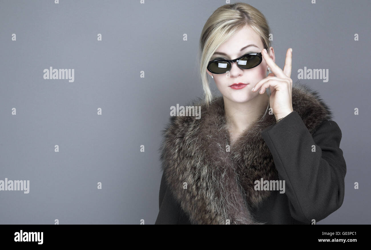Young woman wearing sunglasses and a fur coat Stock Photo - Alamy