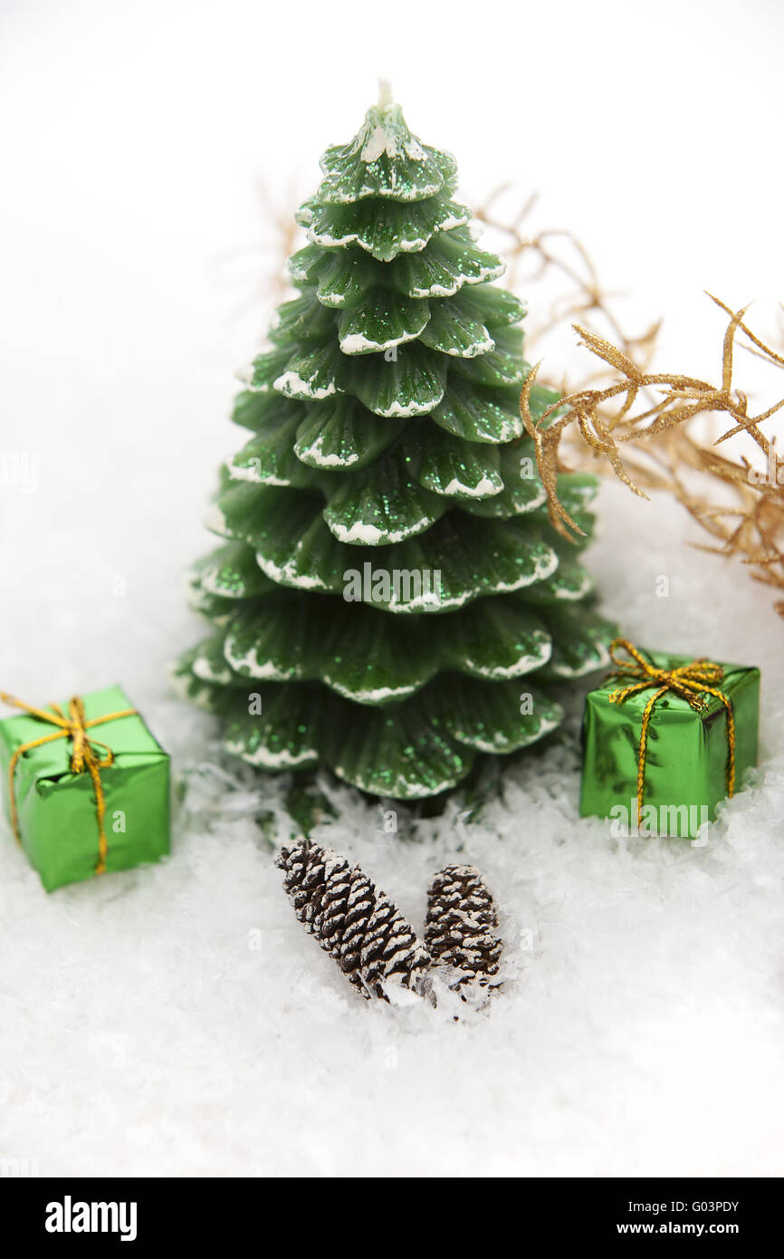 Christmas candle in the snow with gift packages Stock Photo