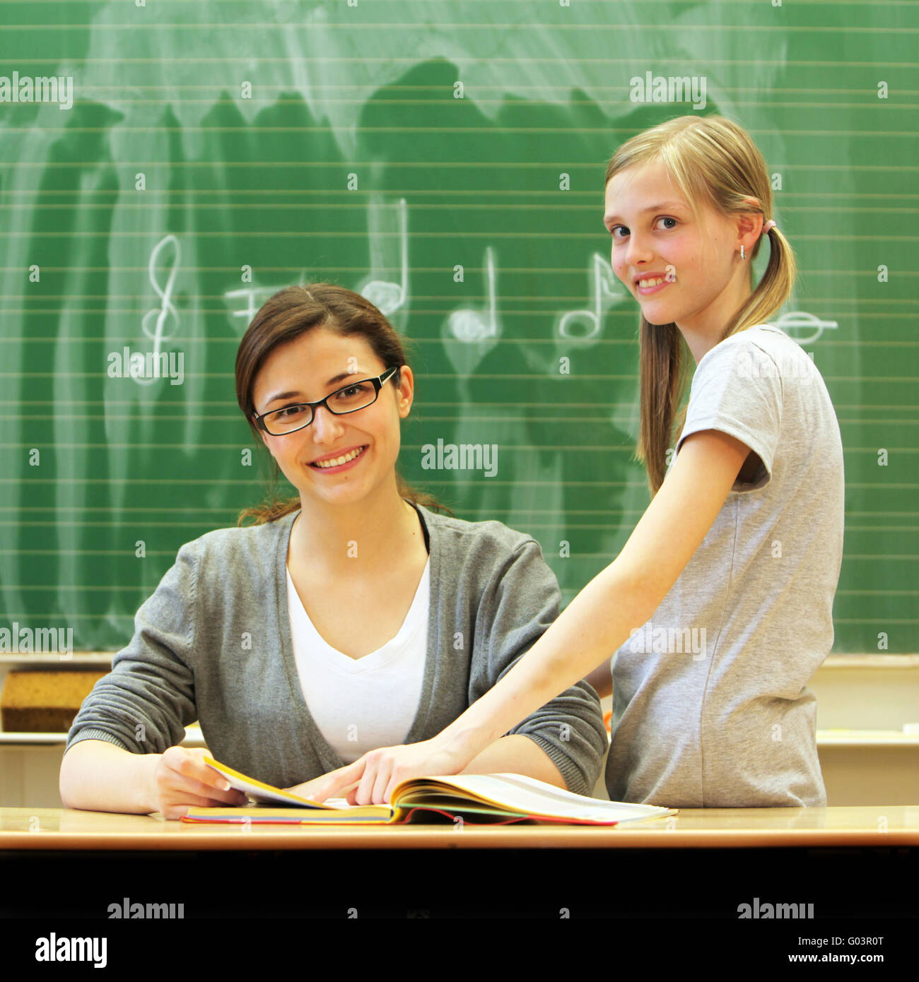Young friendly teacher and student in the classroo Stock Photo