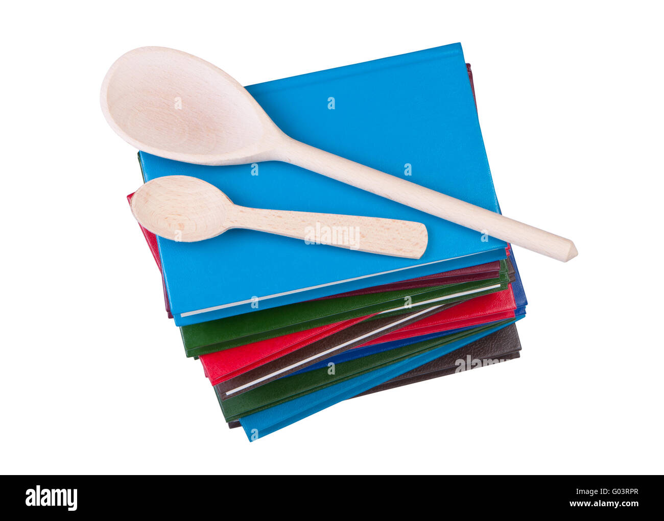 Stack of books with wooden spoons isolated on white background. Stock Photo
