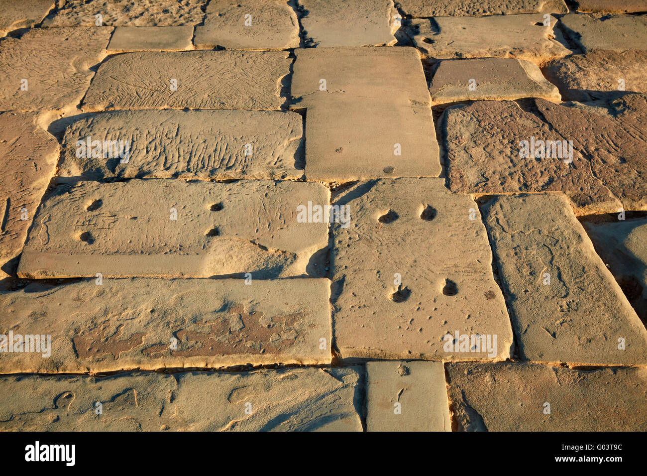 Blocks in ancient sandstone causeway crossing the moat to Angkor Wat