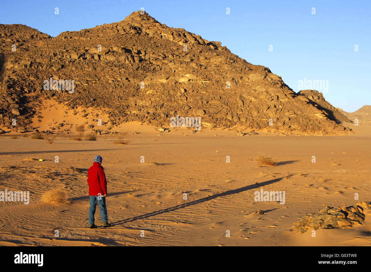 A  person casts a long shadow in a desert Stock Photo