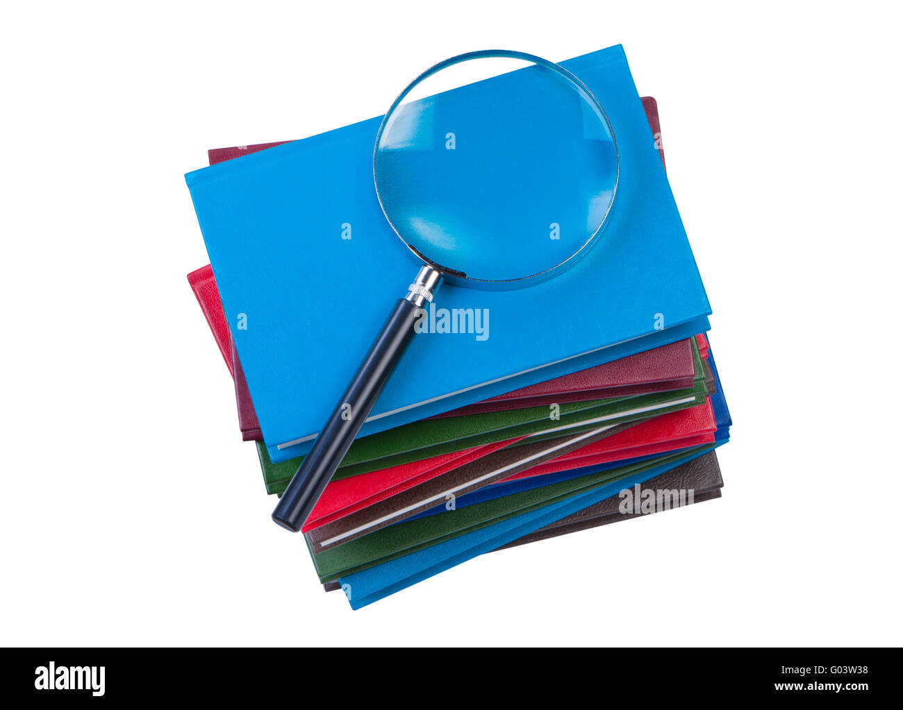 Stack of books with magnifying glass isolate on white background. Stock Photo