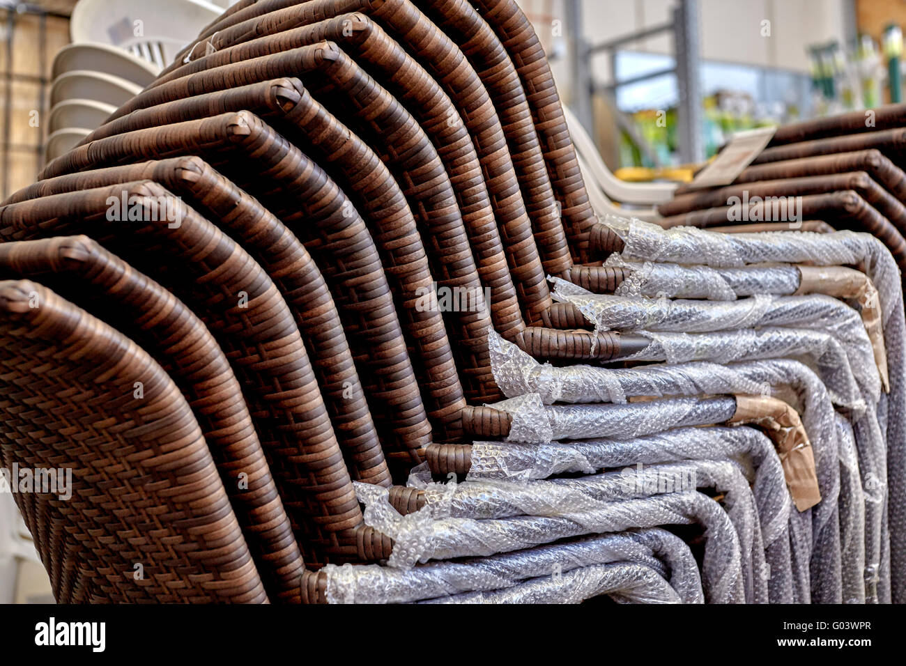 Stack of new wicker patio chairs in a retail store Stock Photo