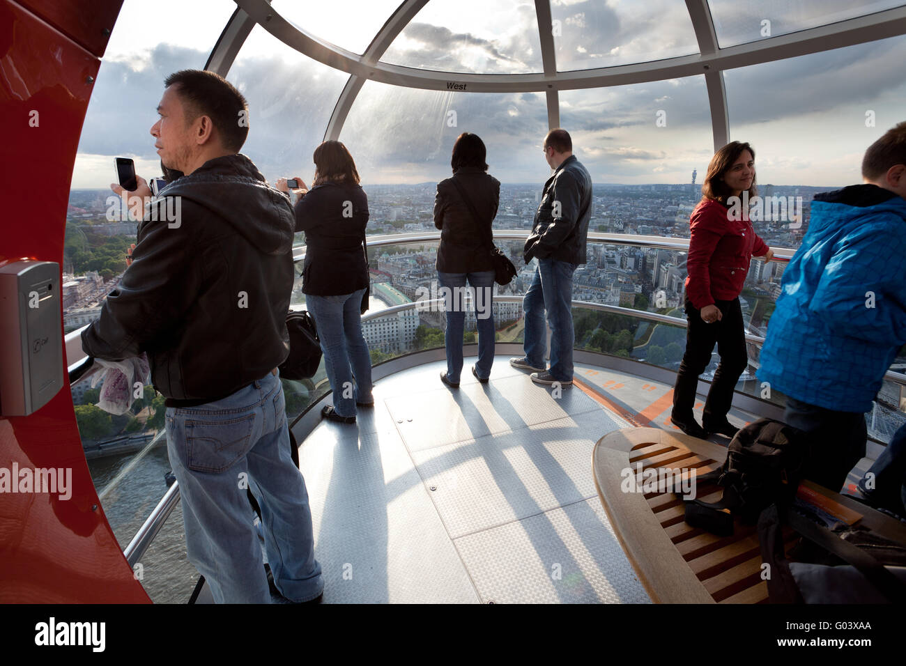 Tourists in the London eye cabin observing city from above Stock Photo