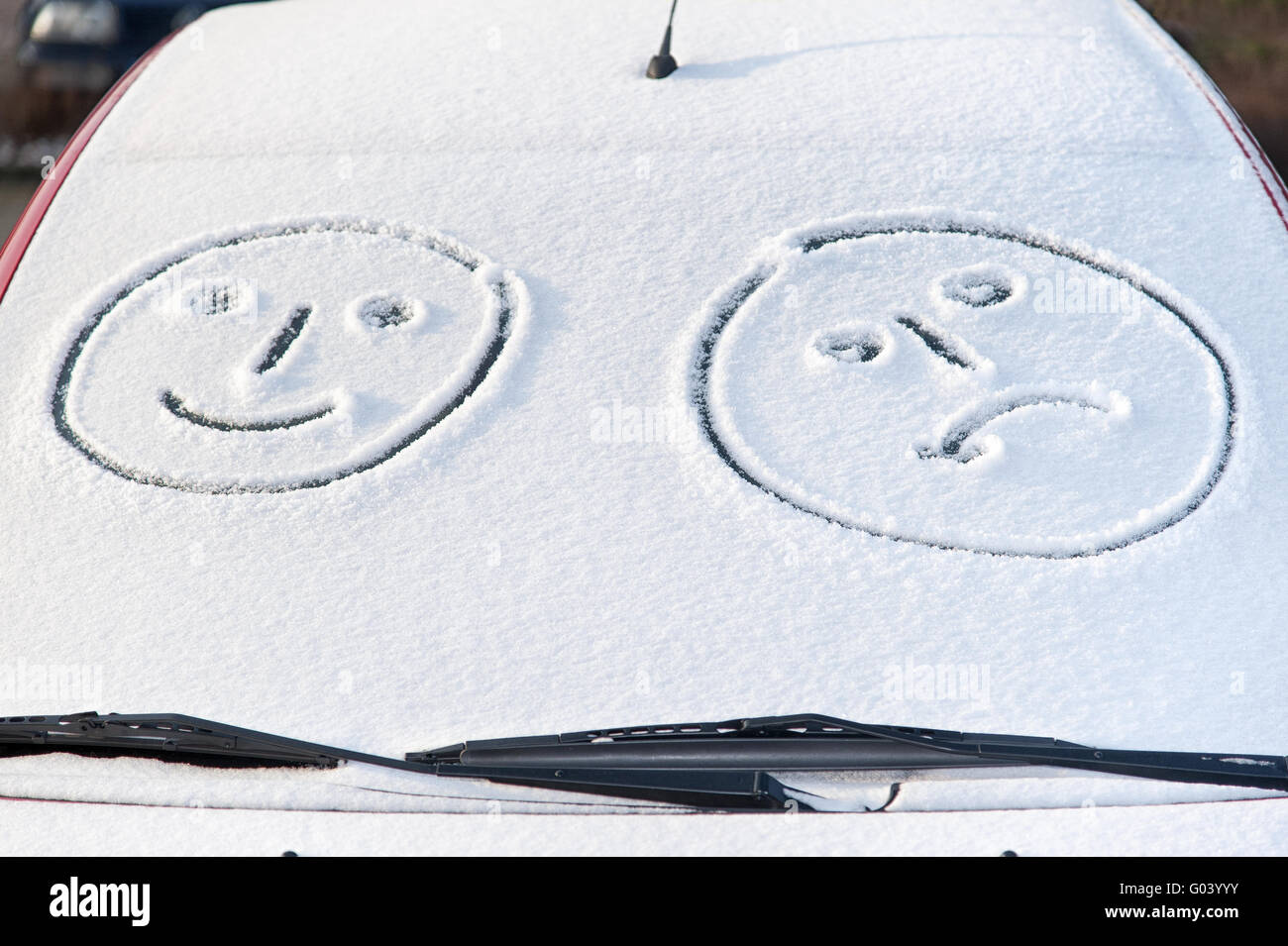 snow-covered windshield of a car with Smileys Stock Photo
