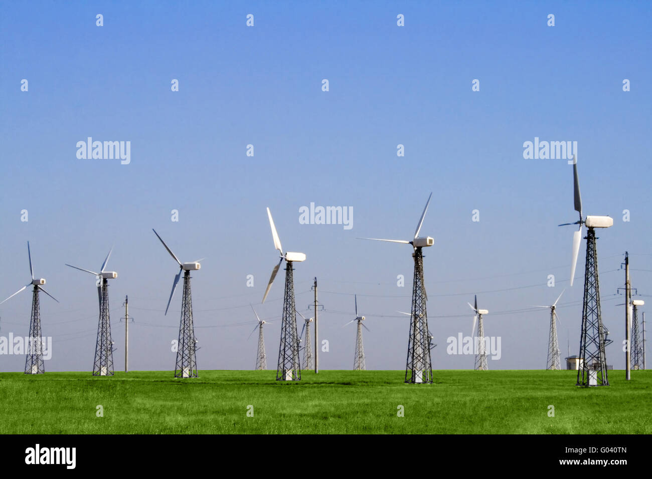 Wind farm turbines in green field over blue sky Stock Photo - Alamy