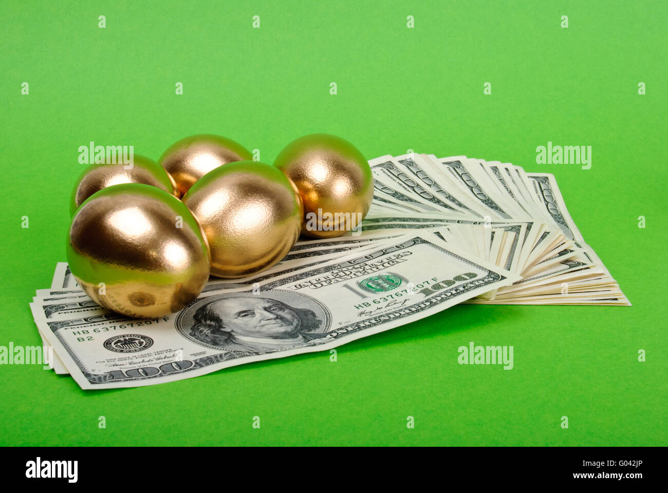 Golden eggs. A symbol of making money and successful investment on green  background Stock Photo - Alamy