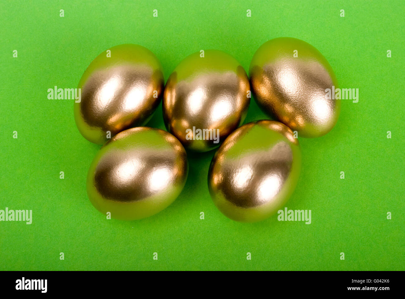 Golden eggs. A symbol of making money and successful investment on green  background Stock Photo - Alamy