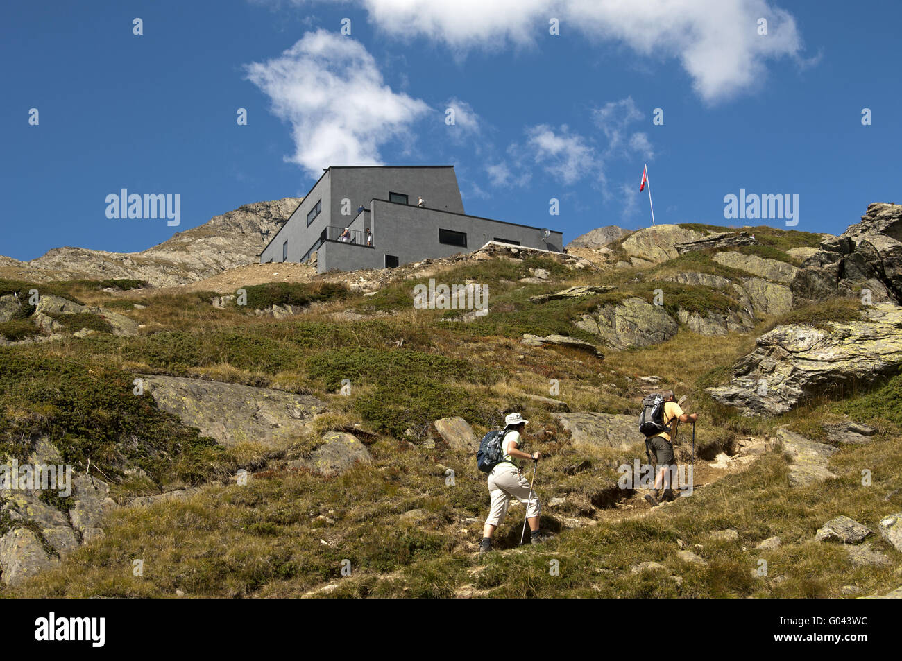 Hikers approaching the Anenhuette, Valais, Switzer Stock Photo