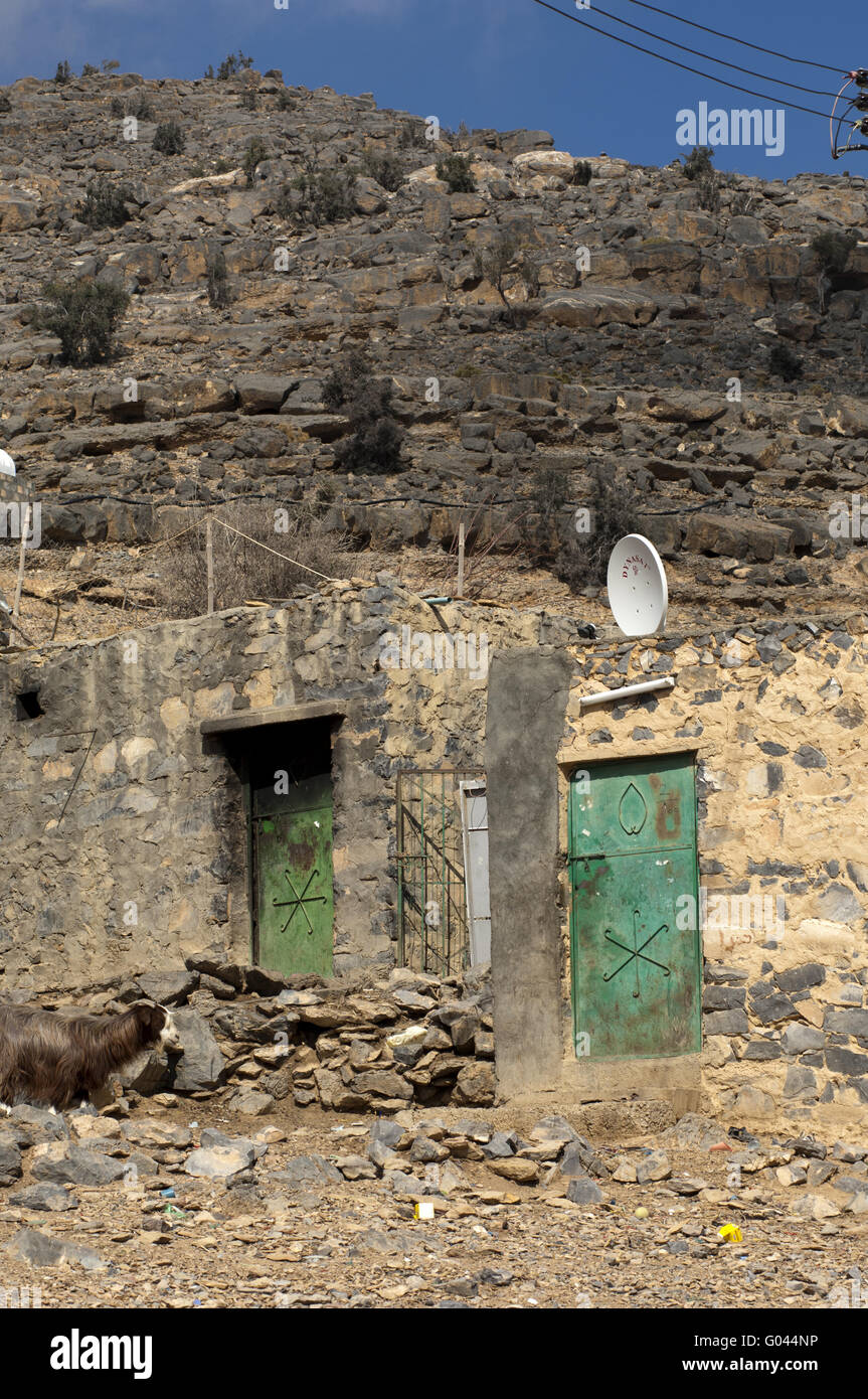 Poor mountain dwelling with satellite dish, Oman Stock Photo