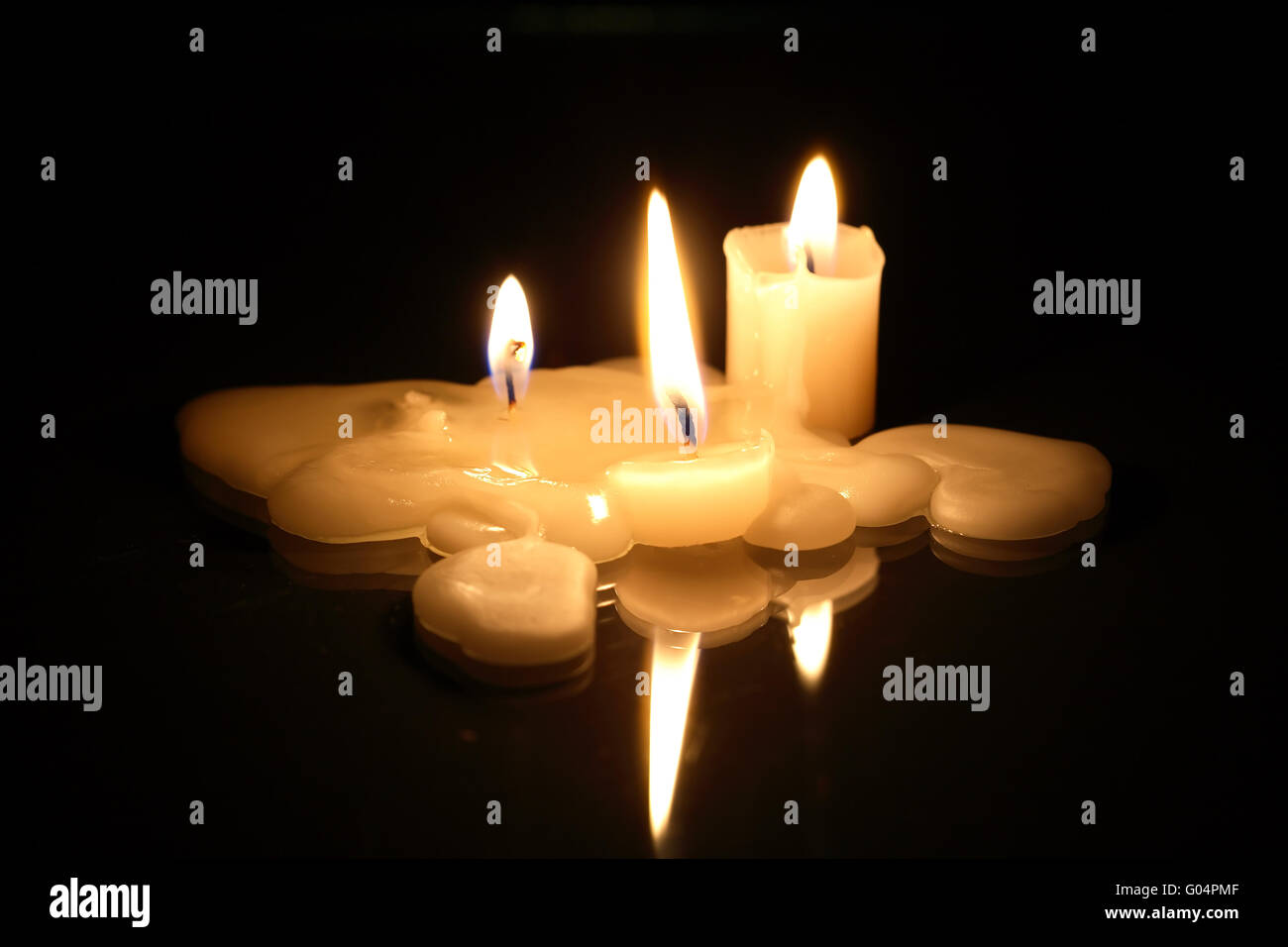 Few lighting candles on dark background with reflection Stock Photo - Alamy