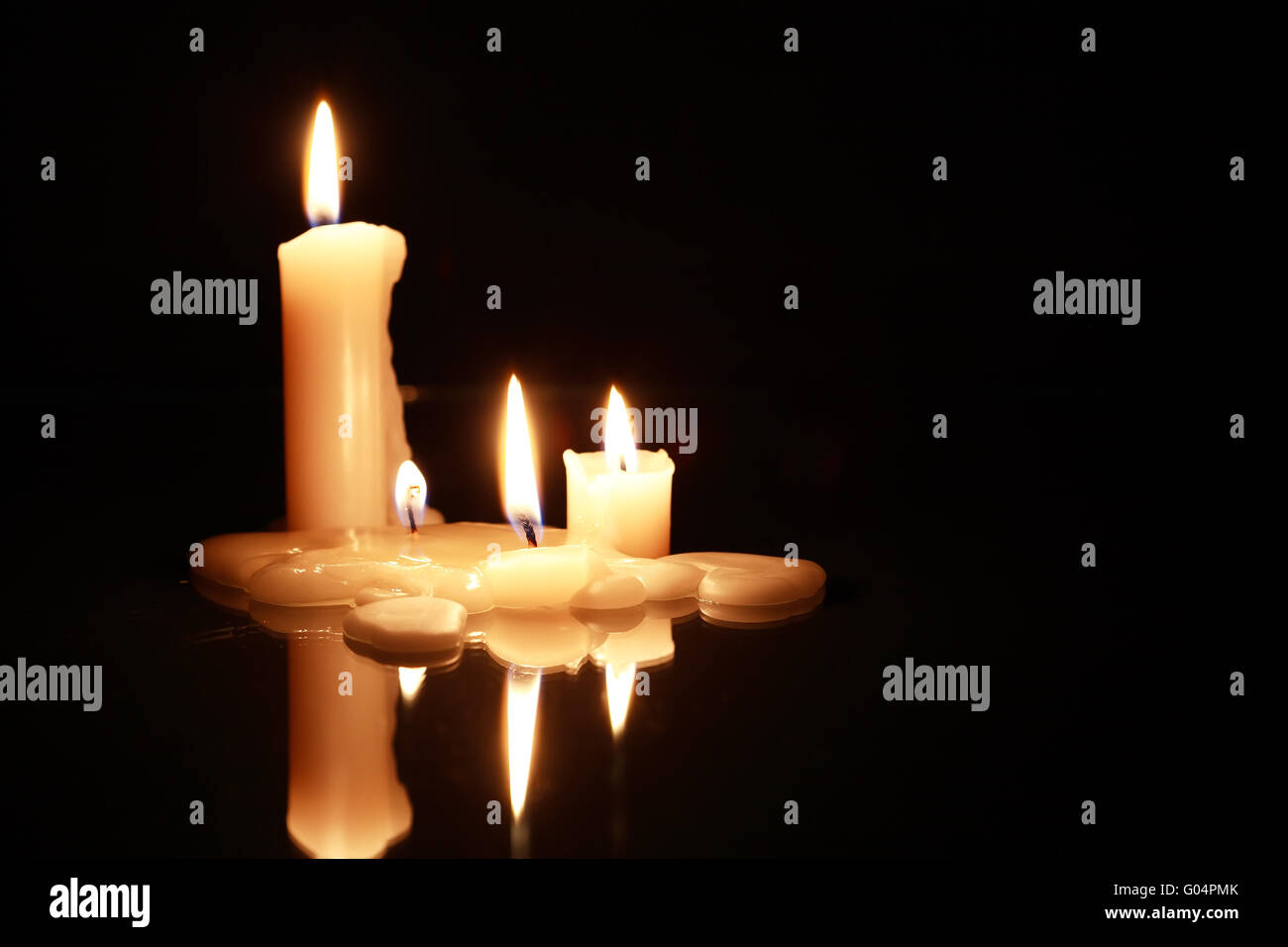 Few lighting candles on dark background with reflection Stock Photo - Alamy