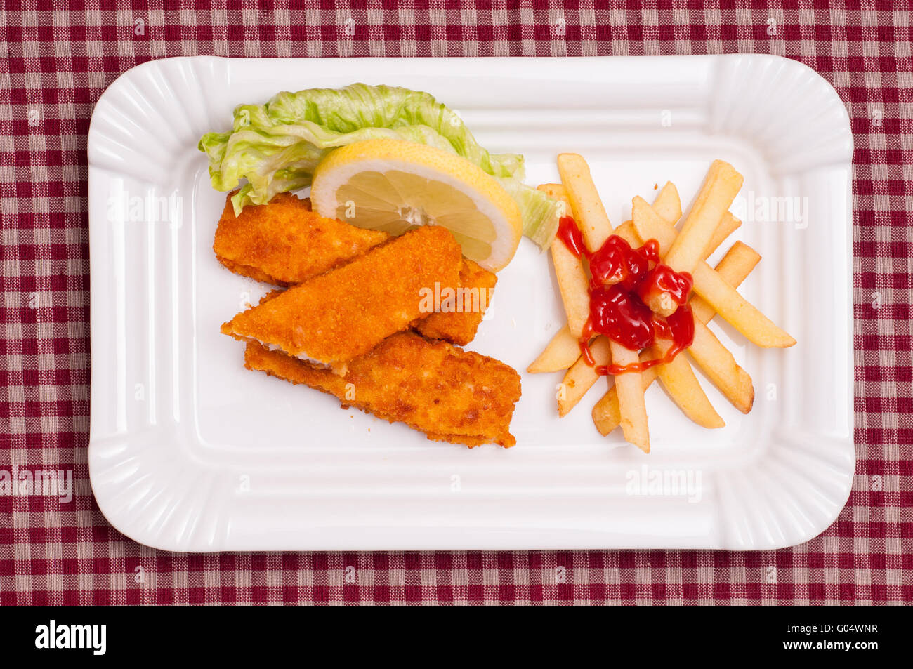 Fish and chips with green salad and a slice of lem Stock Photo