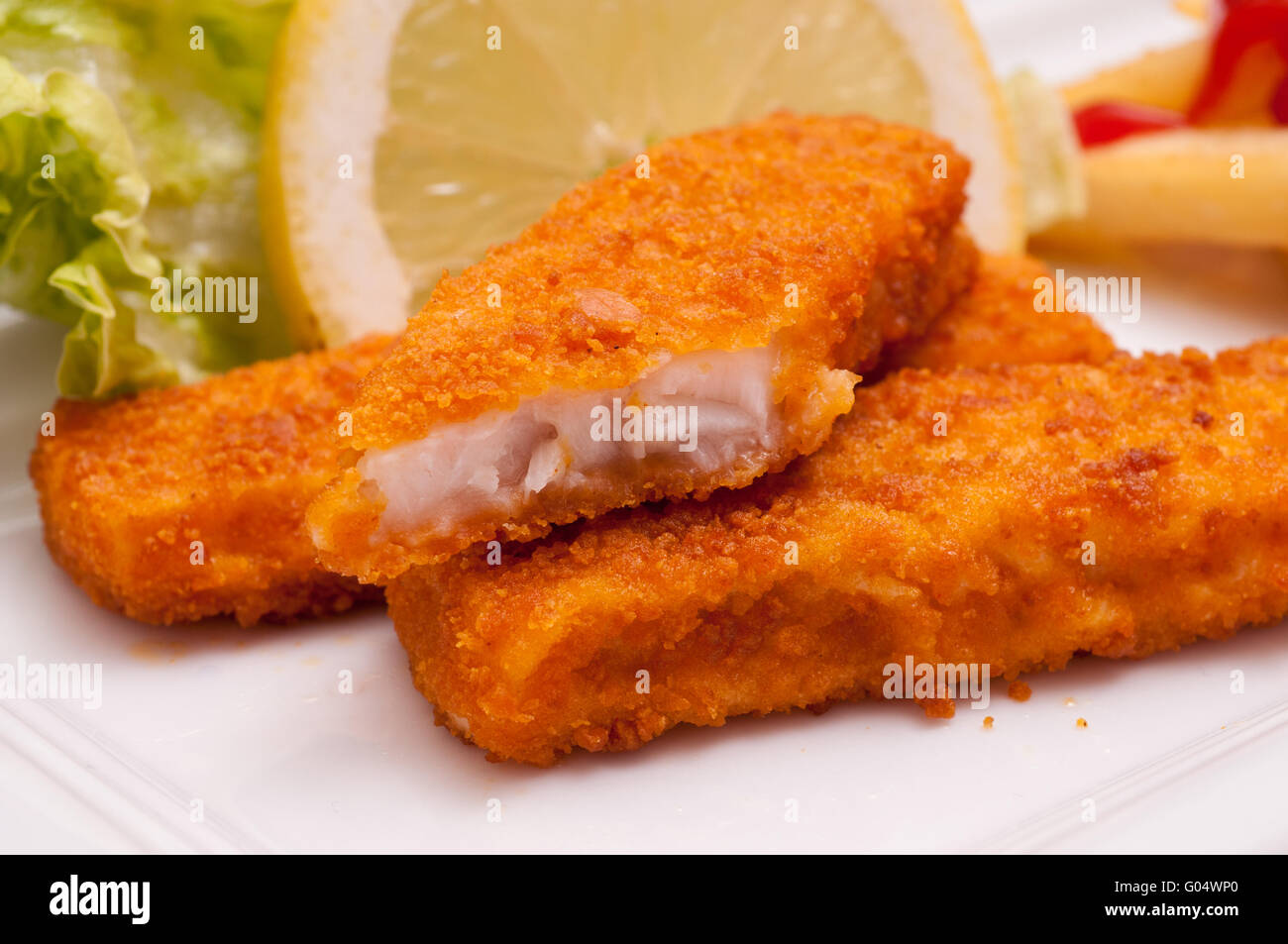 Fast food with breaded fish fingers and a lemon Stock Photo