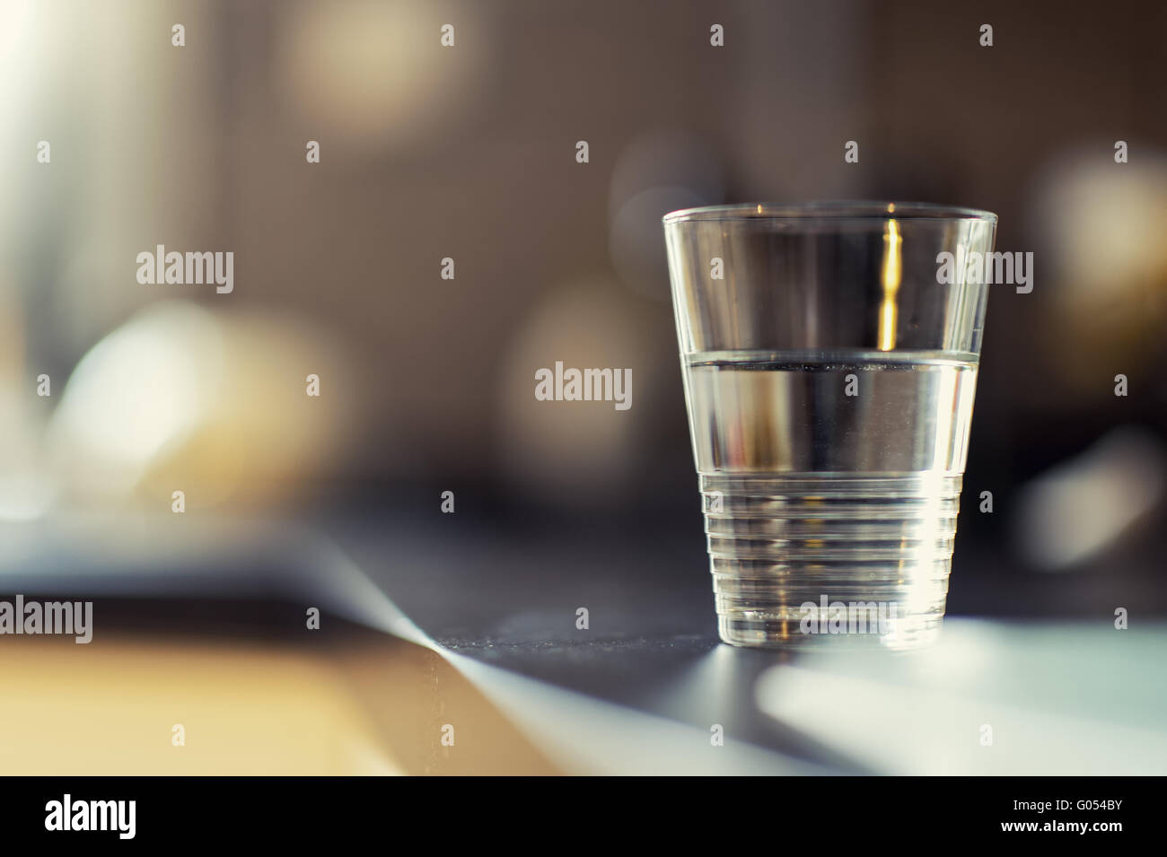 a half-full glass of water standing on the kitchen Stock Photo