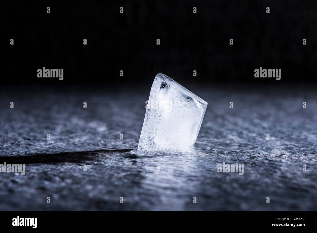 Melting ice cube in close up. Concept of cold temperature, water and change. Stock Photo