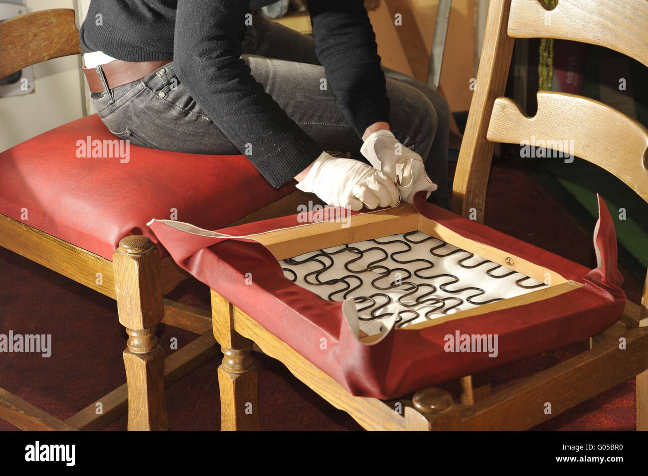 Woman upholstering a kitchen stool. Stock Photo