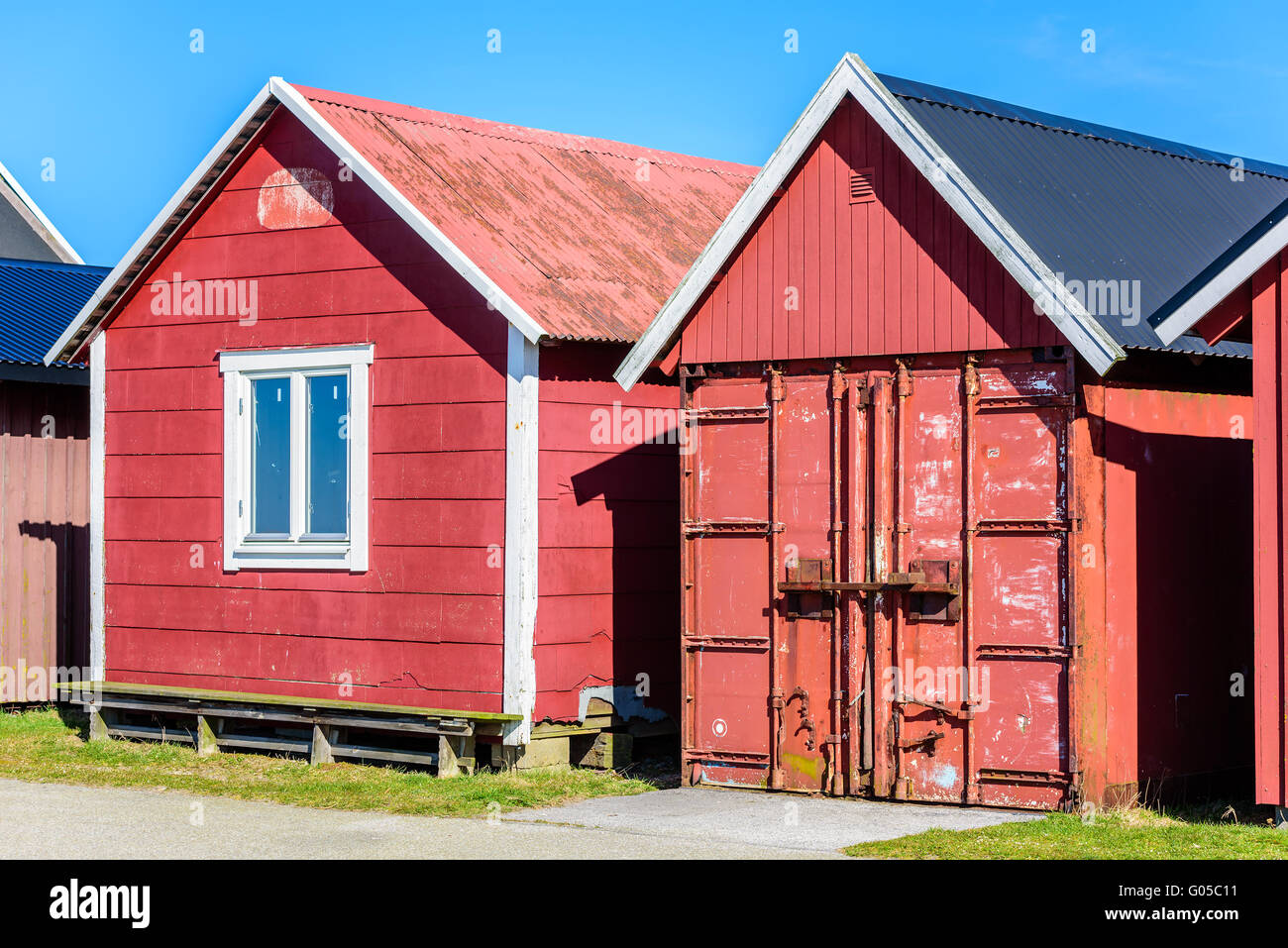 Falsterbo, Sweden - April 11, 2016: Two fishing cabins or tool sheds in the harbor. One is an up cycled cargo container with a r Stock Photo