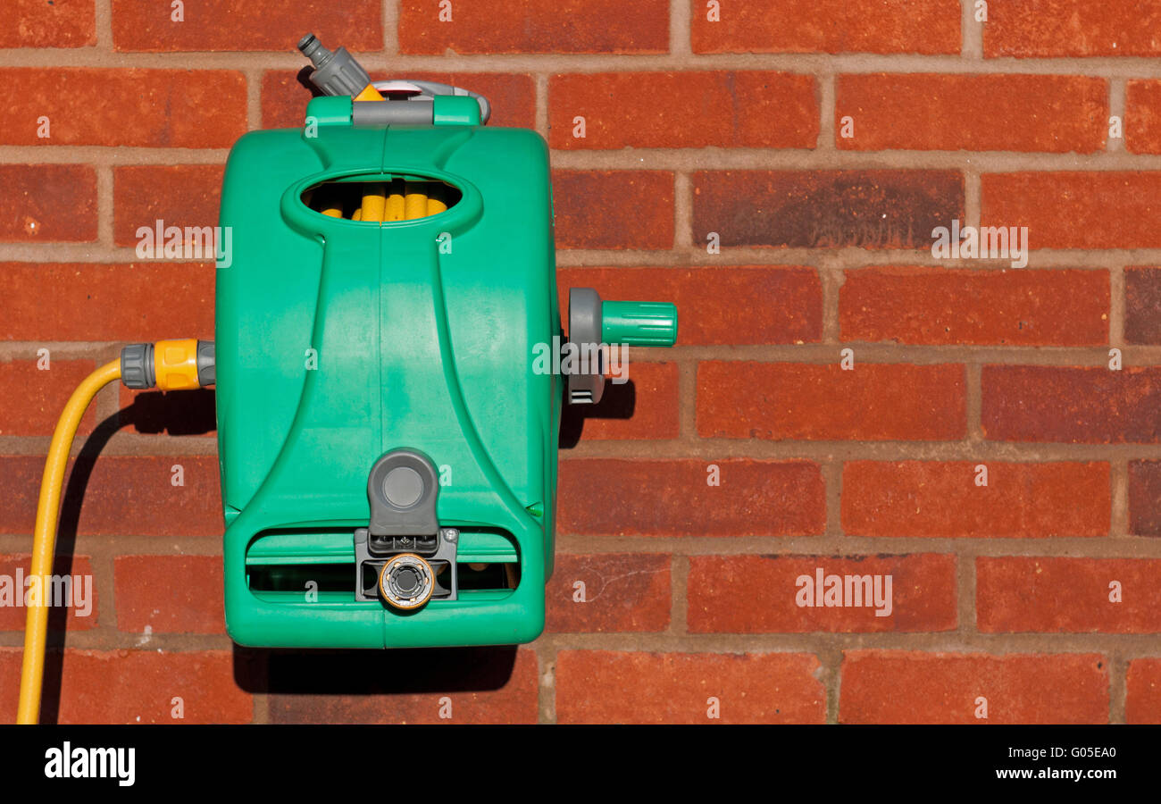 garden hose reel kit installed on a brick wall (copyspace available
